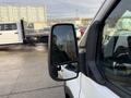 Side mirror of a 2023 Ford Transit with a clear reflection showing the vehicle's body