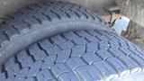 A close-up view of two large tires mounted on a 2011 Ford Econoline showing detailed tread patterns and thick rubber surfaces