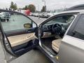 A 2019 Subaru Outback with the driver's side door open showing a beige interior and dashboard with various controls and a steering wheel