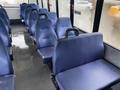 Interior seating of a 2017 Chevrolet Express featuring rows of blue upholstered seats with armrests and a glossy floor surface