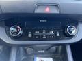 The interior dashboard controls of a 2012 Kia Sportage featuring climate control knobs and a display panel for air conditioning settings