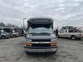 A 2017 Chevrolet Express van in the foreground with a prominent front grille and headlights visible