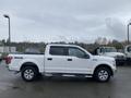 A white 2017 Ford F-150 pickup truck with a crew cab and four-wheel drive badge parked in a lot