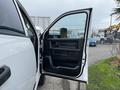 A white 2018 RAM 3500 truck with the driver's side door open showcasing the interior door panel and handle