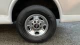 Close-up of a chrome wheel rim and tire from a 2005 Chevrolet Express van with a distinct design and tread pattern