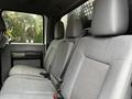 Interior view of the rear seats of a 2014 Ford F-550 with gray fabric upholstery and seat belts