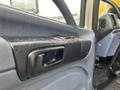 The interior door handle of a 2008 Hino Conventional Cab with a partially wet surface and features a sleek black design