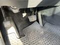 The floor area of a 2012 Kia Sportage showing the accelerator and brake pedals along with a rubber floor mat