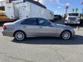 A silver 2007 Mercedes-Benz E-Class sedan with a sleek design and prominent wheel rims parked on a lot