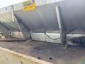 A 2010 Ford F-550 vehicle with a metallic gray dump bed and a warning sign that says Do Not Fill Above Grate