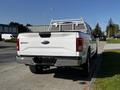 White 2017 Ford F-150 with a ladder rack on the bed parked on a street