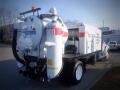 A white 2007 Ford F-650 vacuum truck with red and black accents and large tanks on the back designed for liquid waste collection and removal