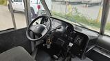 A 2006 Ford Econoline interior featuring the steering wheel dashboard and gear shift with various controls and keys hanging from the ignition