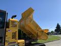 A yellow 2022 TerraMac RT7R with the dump box raised revealing its interior features and hydraulic mechanisms