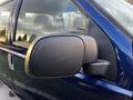 Side view mirror of a blue 2008 Ford F-250 SD truck with a matte black housing