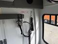 Interior view of a 2010 Ford Econoline showing mobility aid straps and harness attached to the wall