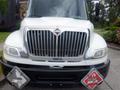 Front view of a white 2015 International 4400 truck featuring a prominent chrome grille and hazard placards on the front bumper