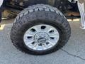 Close-up of a silver alloy wheel mounted on a rugged tire with deep treads designed for off-road performance