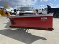 A red Western snow plow attached to a white 2010 Ford F-550 truck
