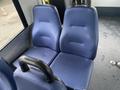 Two blue fabric seats positioned side by side in the passenger area of a 2017 Chevrolet Express van