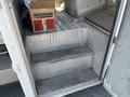 Stairs leading into a 2010 Freightliner MT45 Garbage Truck with diamond plate metal flooring and a cardboard box visible on the steps