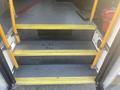 Three yellow steps leading into a vehicle with a gray textured surface and a black area at the top of the steps