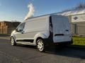 A 2022 Ford Transit Connect van with a white exterior and black accents parked along a road