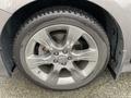 A close-up view of a silver alloy wheel from a 2013 Toyota Sienna featuring five spokes and a tire with a tread pattern visible