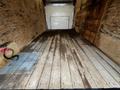 Interior view of a 2017 Ford Econoline van showing a wooden floor with visible streaks and tools in the corner