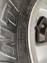 Close-up of a 2017 Ford F-150 tire showing the tread pattern and a valve stem for inflation