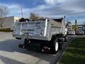 A silver 2011 International 7500 dump truck with an open cargo bed and visible rear lights parked on a driveway