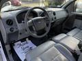 Interior of a 2008 Ford F-150 XL featuring a steering wheel dashboard and gray seating with a thank you mat on the floor