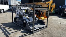 A 2024 Power JQ 400 compact track loader is displayed in a transport frame with a front bucket attachment visible on the machine