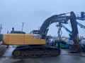 A yellow and black 2014 John Deere 350G excavator with a large digging bucket positioned on a muddy surface