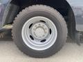 Close-up of a silver wheel with a large tire, featuring five lug nuts, mounted on the side of a food truck