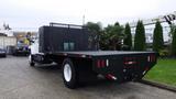 A 2008 Chevrolet C7500 truck with a flatbed and black mesh safety guard at the rear