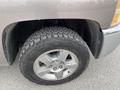 Close-up of a tire and wheel from a 2013 Chevrolet Silverado Hybrid showcasing rugged tread patterns and alloy rim design