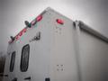 Rear view of a 2003 Freightliner MT45 Chassis showing the red taillights and a metal door with a latch on the side