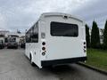 A white 2017 Chevrolet Express bus viewed from the rear showcasing its large windows and rear lights