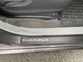 A close-up view of the interior door sill of a 2013 Toyota Sienna featuring the name Sienna embossed on the mat