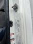 A close-up view of the door handle and identification stickers on a 2008 Hino 268 truck door