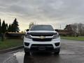 A white 2018 Chevrolet Colorado viewed from the front with a black grille featuring a gold Chevrolet emblem