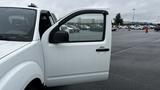 A 2016 Nissan Frontier with an open driver's side door showing the interior and window with raindrops