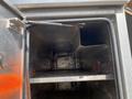 Interior of a storage compartment in a 2010 Ford F-550 featuring metal construction and dividers