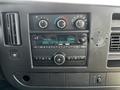 The dashboard of a 2015 Chevrolet Express featuring climate controls and a radio with a digital display