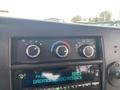 Close-up of the dashboard controls of a 2017 Chevrolet Express featuring knobs for temperature and airflow settings along with a digital radio display