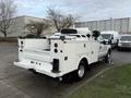 A 2013 Ford F-350 SD truck with a white utility bed and multiple compartments for tools and equipment