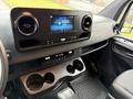 Interior view of a 2019 Mercedes-Benz Sprinter showing the dashboard with a touchscreen display and cup holders