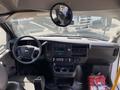 Interior view of a 2017 Chevrolet Express showing the dashboard steering wheel and controls with a large rearview mirror above