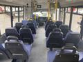 Interior of a 2017 Chevrolet Express bus featuring several rows of blue upholstered seating and a driver's area with a dashboard and steering wheel